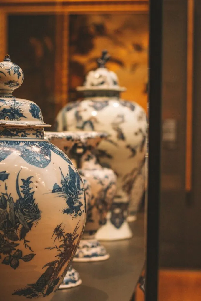 Urnes en porcelaine chinoise blanche et bleue ornés de motifs traditionnels exposés sous vitrine